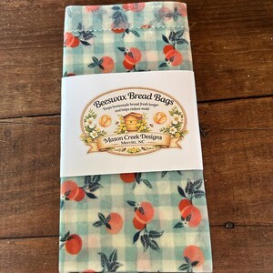 May include: Beeswax bread bags with a peach and leaf pattern on a light green and white checkered background. The bags have a white label that reads "Beeswax Bread Bags" and "Mason Creek Designs, Merritt, NC."
