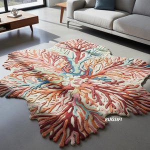 Puede incluir: Una alfombra con forma de coral con un fondo crema y un diseño de arrecife de coral colorido en tonos rojos, naranjas, azules y rosas. La alfombra está colocada sobre un suelo gris en un salón.