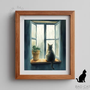 May include: A framed print depicts a cat gazing out a window at the rain. The cat sits on a wooden windowsill next to a potted plant. The window is open, and the scene is painted in shades of blue and gray. The frame is a warm brown.