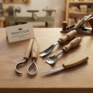 May include: A set of five wood carving tools with light-colored wooden handles and metal blades, including hook knives, gouges, and a detail knife. A white card displays the text Empire Cutlery Handcrafted Wood Carving Tools Since 1980.