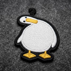 May include: Embroidered patch featuring a cartoon duck with a question mark above its head. The duck is white with a black outline, yellow beak and feet. The patch is on a gray background.