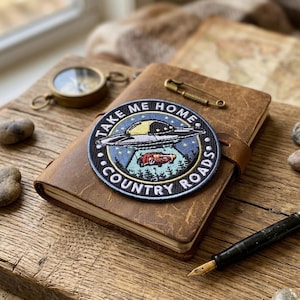 May include: A rustic wooden sign with the text "Welcome to our home" in white lettering. The sign features a distressed finish and a simple, inviting design, perfect for a front porch or entryway.