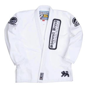 Peut inclure: Uniform blanc d'arts martiaux avec logos et texte noirs et blancs. L'uniforme comporte un col, des revers et des coutures renforcées. Le texte sur l'uniforme indique "Shoyoroll Brand" et "Shoyoroll Kimonos".