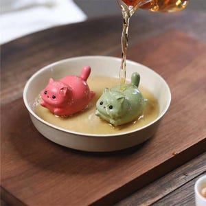 May include: A set of three ceramic nesting bowls in shades of blue, green, and white. The bowls have a speckled glaze and a simple, modern design. The largest bowl is approximately 15 cm in diameter.