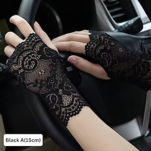 May include: A pair of black lace fingerless gloves, about 15 cm long, are displayed. The gloves have a detailed floral design and are worn on both hands. The text "Black A(15cm)" is visible at the bottom of the image.