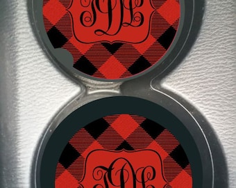May include: Two black and red checked car coasters with a monogram of the letters "JD" in a black frame.