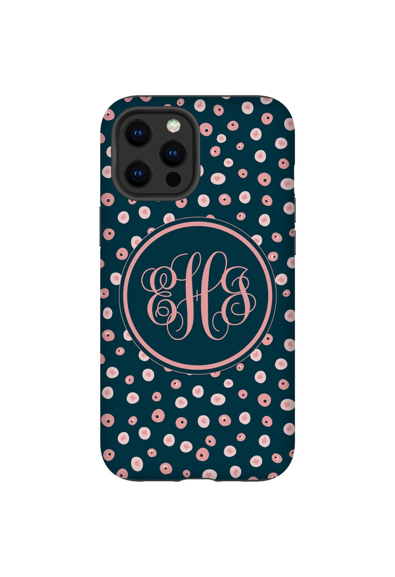 K&ouml;nnte beinhalten: Eine dunkelblaue Handyh&uuml;lle mit einem rosa-wei&szlig;en Tupfenmuster. Die H&uuml;lle hat einen Kreis in der Mitte mit einem rosa Monogramm "JLS" in einer Schriftart.