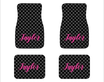 May include: Set of four black and white checkered car floor mats with the name "Taylor" in pink lettering.