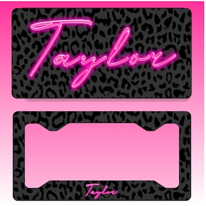 May include: A license plate and license plate frame set. The license plate has a black leopard print background with the name "Taylor" in bright pink neon lettering. The frame has a matching leopard print border and the name "Taylor" in the bottom right corner.