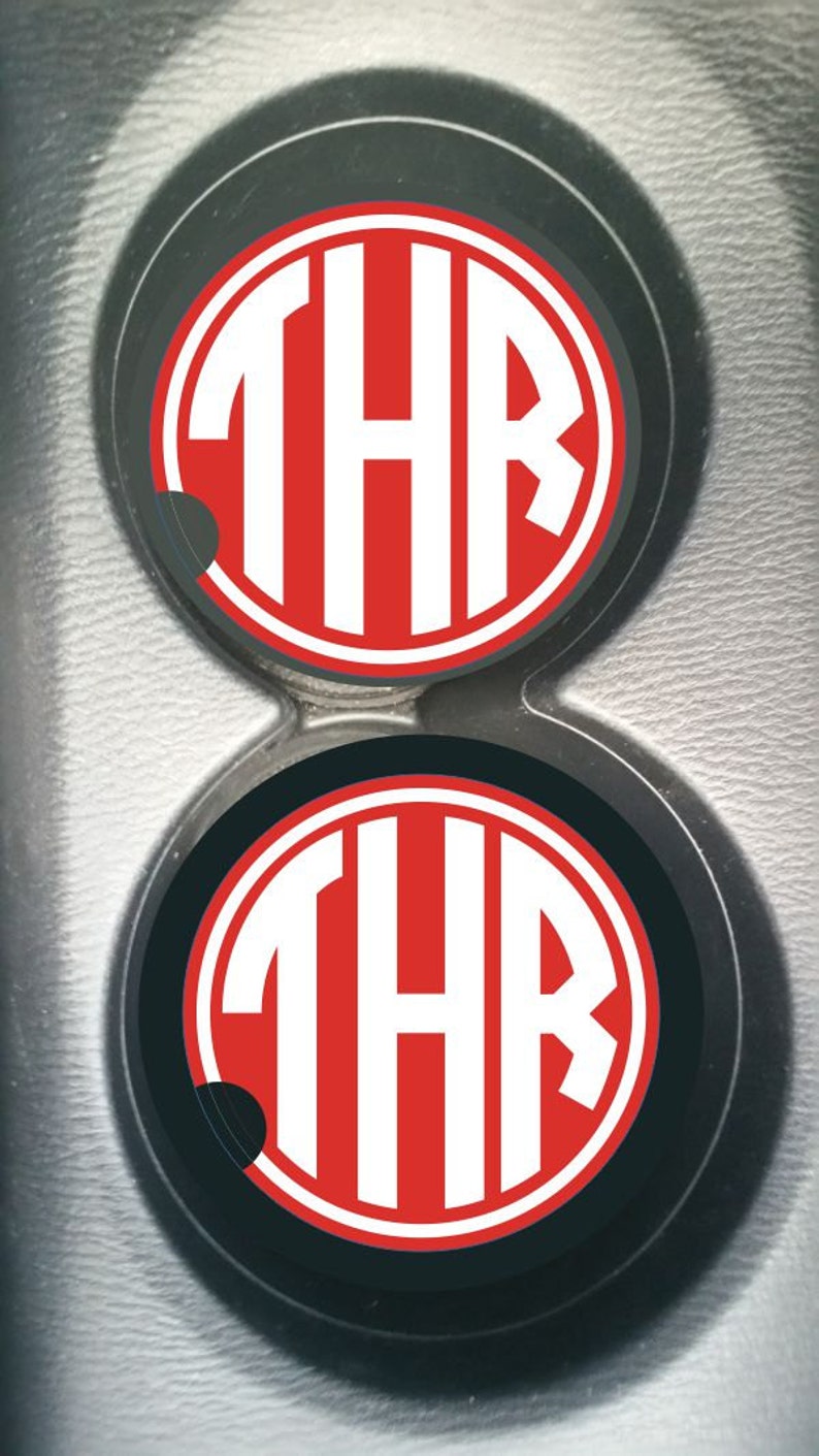 May include: Two black and red car coasters with the letters "THR" in white.