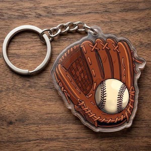 May include: A baseball-themed keychain featuring a baseball glove and a baseball. The glove is brown with detailed stitching, and the baseball is white with black stitching. The keychain has a silver-colored ring and chain.
