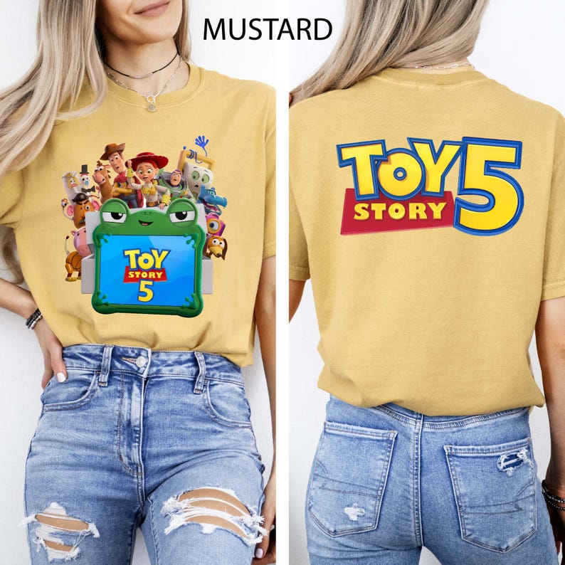 May include: A mustard yellow t-shirt featuring a front graphic of various Toy Story characters surrounding a green frog-shaped frame with the text Toy Story 5. The back of the shirt displays the large blue and yellow text Toy Story 5.