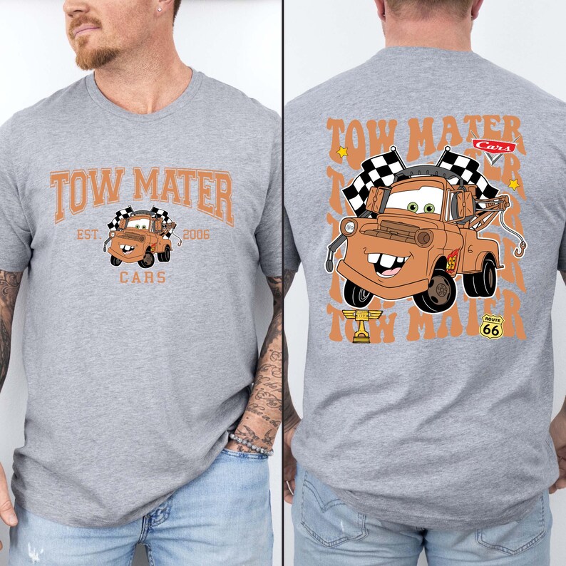 Puede incluir: Una camiseta gris jaspeado con el personaje Tow Mater de la pel&iacute;cula Cars. La parte delantera de la camiseta tiene el texto "Tow Mater" y "Cars" con una imagen de Mater. La parte trasera de la camiseta tiene una imagen m&aacute;s grande de Mater con banderas a cuadros.