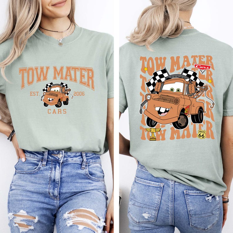 Puede incluir: Camiseta verde claro con una imagen de dibujos animados de Mate de la pel&iacute;cula Cars. La parte delantera de la camiseta tiene el texto "Tow Mater" y "Cars". La parte trasera tiene una imagen m&aacute;s grande de Mate con banderas a cuadros.