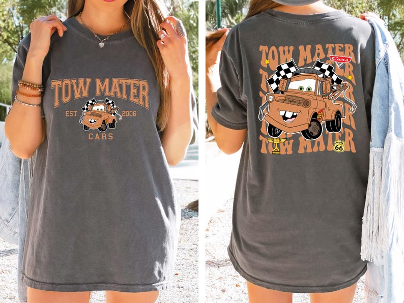Puede incluir: Camiseta gris oscuro con una imagen de dibujos animados de Mate de la pel&iacute;cula Cars. La parte delantera de la camiseta tiene el texto "TOW MATER" encima de la imagen, con "EST. 2006" y "CARS" debajo. La parte trasera repite el texto y la imagen.