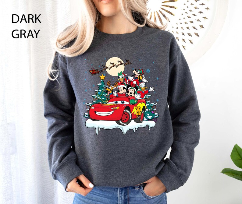 K&ouml;nnte beinhalten: Dunkelgraues Sweatshirt mit festlichem Design mit Disney-Figuren in einem roten Rennwagen, einem Weihnachtsbaum und einem Vollmond. Der Text "DARK GRAY" befindet sich in der oberen linken Ecke. Der Pullover ist ein bequemer, l&auml;ssiger Stil.