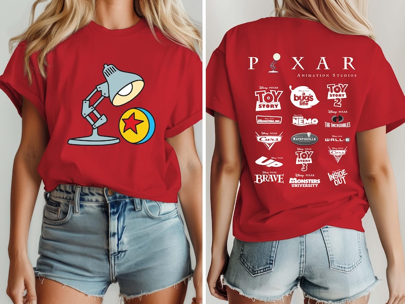 May include: Red t-shirt featuring a cartoon image of the Pixar lamp and ball on the front. The back of the shirt displays the Pixar logo and logos from various Pixar movies, including Toy Story, Cars, and Finding Nemo.