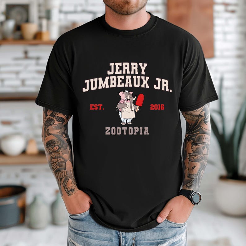 May include: Black t-shirt featuring the text "JERRY JUMBEAUX JR." above an illustration of an elephant holding a red popsicle. The shirt also includes the text "EST. 2016" and "ZOOTOPIA".