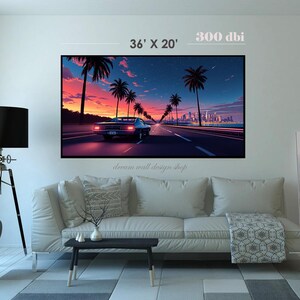 May include: A framed wall art print depicting a classic car driving down a road lined with palm trees at sunset. The artwork features a vibrant color palette of orange, pink, and blue. The print measures 36' x 20'. The text "dream wall design shop" is at the bottom.