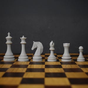 May include: A complete set of white chess pieces arranged on a wooden chessboard. The pieces include a king, queen, knight, bishop, rook, and pawn. The board has a classic brown and tan checkered pattern.