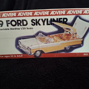 May include: A model kit box depicting a '59 Ford Skyliner. The box shows a yellow and white car with its retractable hardtop open. Text on the box reads "Retractable Hardtop 1/25 Scale" and "For Ages 10 to Adult."