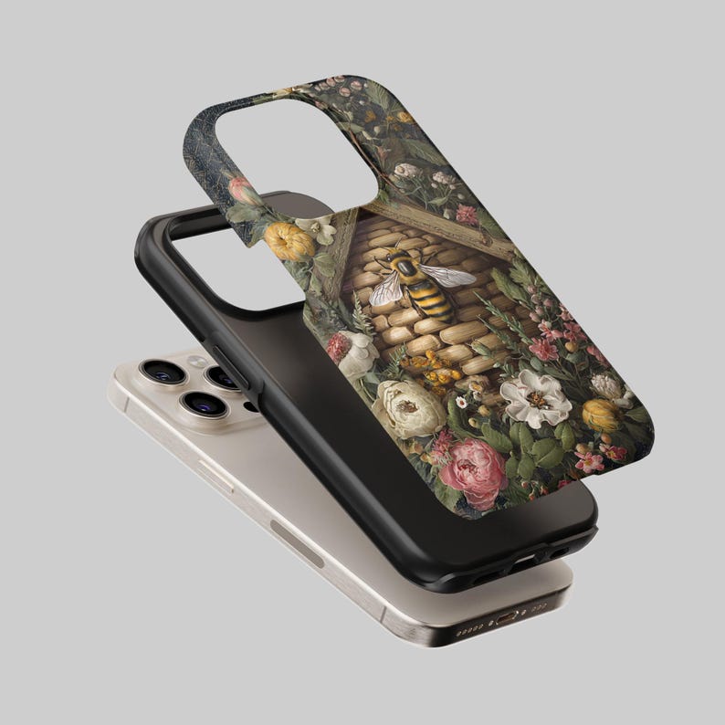 May include: A phone case featuring a detailed illustration of a bee and a beehive surrounded by colorful flowers. The case has a black border and is layered over a silver phone.