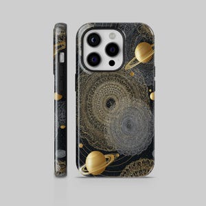 Peut inclure: Coque de téléphone noire avec un motif céleste doré et argenté. Le motif répète des planètes et des formes complexes en forme de mandala. Le côté de la coque est noir avec des accents dorés. Conçu pour un smartphone.