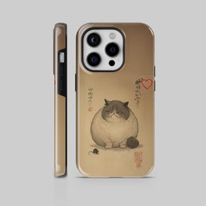 May include: A phone case featuring a grumpy cat illustration in a traditional Japanese art style. The cat is gray and white, with a stern expression. The case has a brown background with Japanese text and a red heart.