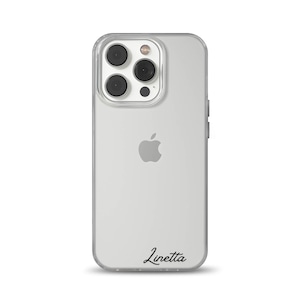 Könnte beinhalten: Transparente Handyhülle mit einem silbernen iPhone. Die Hülle hat einen transparenten Stoßfänger und eine schwarze Schrift, die unten "Linetta" steht. Das Telefon hat eine Dreifach-Kamera und das Apple-Logo.
