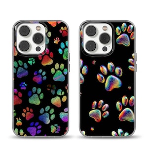 Op de afbeelding: Twee telefoonhoesjes met een zwarte achtergrond en een patroon van kleurrijke pootafdrukken. De pootafdrukken zijn in tinten rood, oranje, geel, groen, blauw en paars. De hoesjes hebben een transparante rand en een camera-uitsparing.