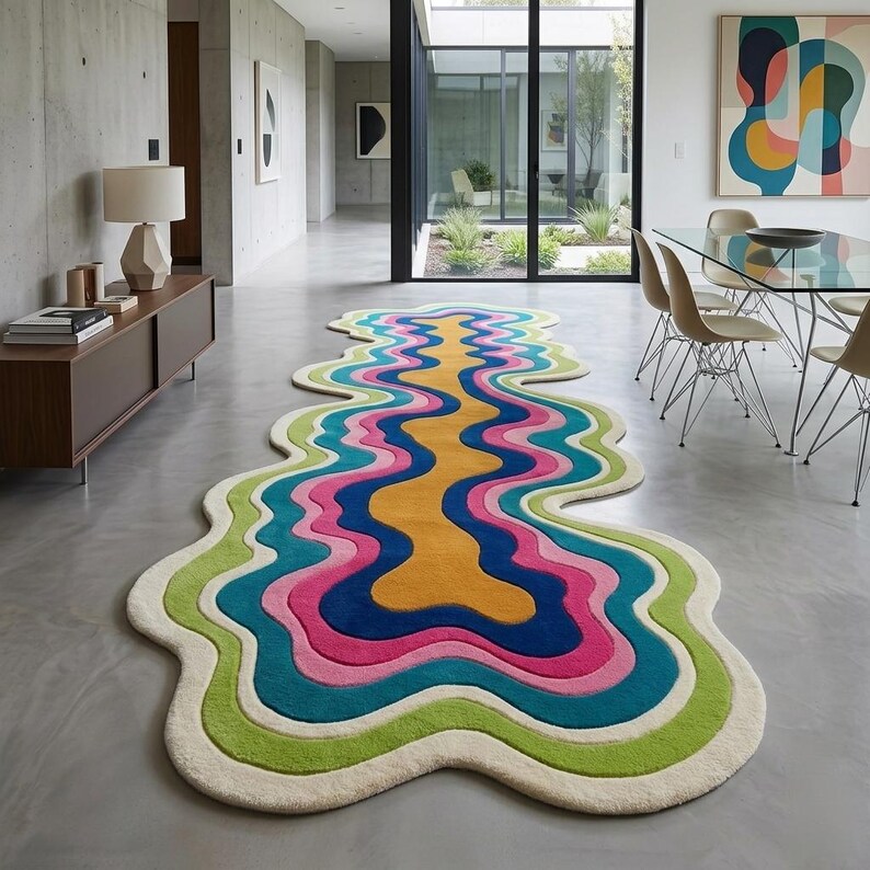 Colorful wavy abstract area rug featuring layered organic curves in green, turquoise, pink, navy blue, mustard yellow, and ivory. Plush raised tufted texture and sculptural irregular shape create a bold modern statement. Shown in a luxury hallway and on a neutral floor, this colorful area rug is ideal for living rooms, bedrooms, hallways, studios, offices, and contemporary interiors.
