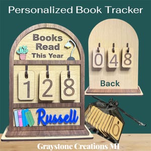 May include: A wooden book tracker with the text "Personalized Book Tracker". The tracker displays "Books Read This Year" and the number "128". It includes a name, a cactus, a lamp, and a stack of books. The back shows the number "048".