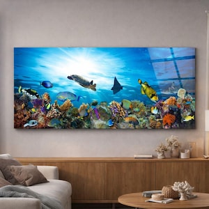 Könnte beinhalten: Ein großer rechteckiger Wandkunstdruck, der eine Unterwasserszene darstellt. Das Bild zeigt ein lebhaftes Korallenriff mit bunten Fischen, einer Meeresschildkröte und einem Mantarochen. Der Hintergrund ist ein helles Blau mit Sonnenlicht, das durch das Wasser scheint.