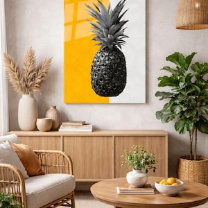 Könnte beinhalten: Ein schwarz-weißes Ananas-Kunstdruck mit gelb-weißem Hintergrund. Das Kunstwerk wird in einem Wohnzimmer mit einem Holzschrank, einem Rattanstuhl und einem runden Couchtisch ausgestellt.