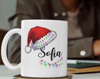 Taza navideña personalizada con nombre, taza navideña con gorro de Papá Noel, regalo navideño personalizado, taza para chocolate caliente, detalle perfecto para la bota navideña