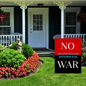 May include: A yard sign with the word "NO" in white on a red background, and "NEITHER IRAN NOR ANYWHERE ELSE." below it. The bottom half is black with the word "WAR" in white. The sign is in a front yard.