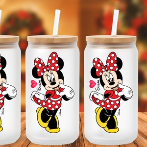 May include: A white ceramic mug with a black handle and the text "But First, Coffee" in a bold, black font. The mug is set against a blurred background, suggesting a cozy setting.