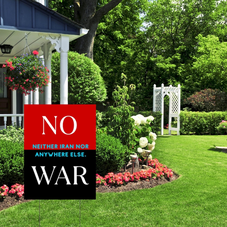 May include: A yard sign with the word "NO" in white on a red background, and the word "WAR" in white on a black background. The text "NEITHER IRAN NOR ANYWHERE ELSE" is between the two words. The sign is in a green yard.