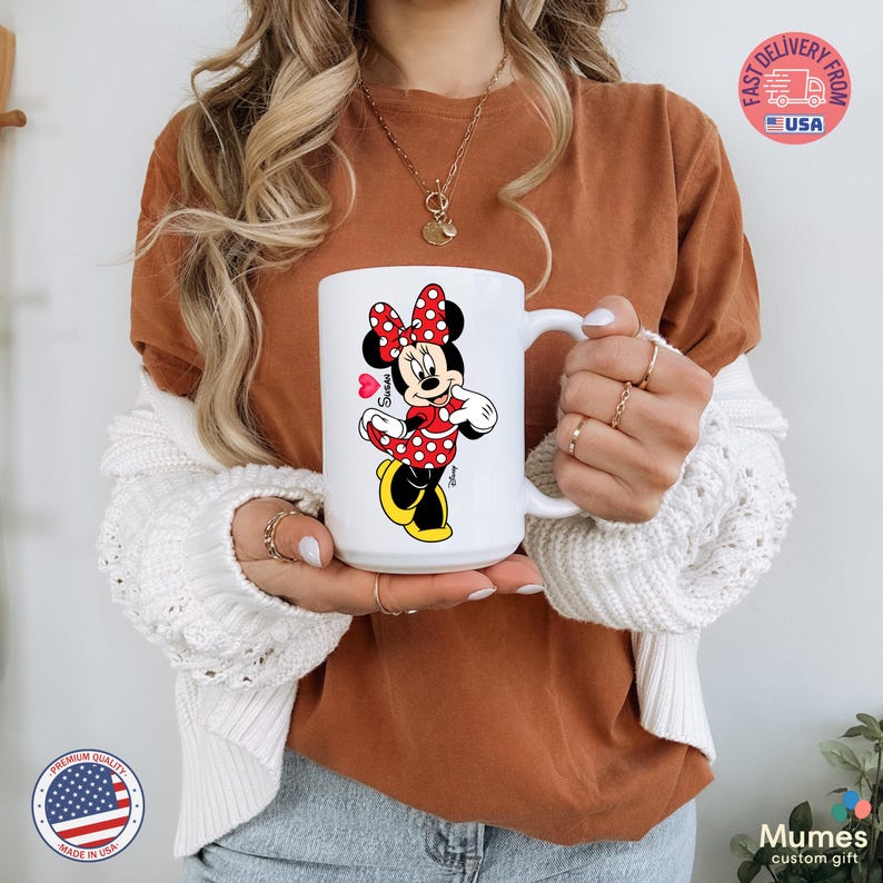 Puede incluir: Taza de cer&aacute;mica blanca con Minnie Mouse con vestido y lazo de lunares rojos. La taza tiene un asa grande y una imagen de dibujos animados de Minnie Mouse. La taza tiene el texto "Susan" y un coraz&oacute;n.