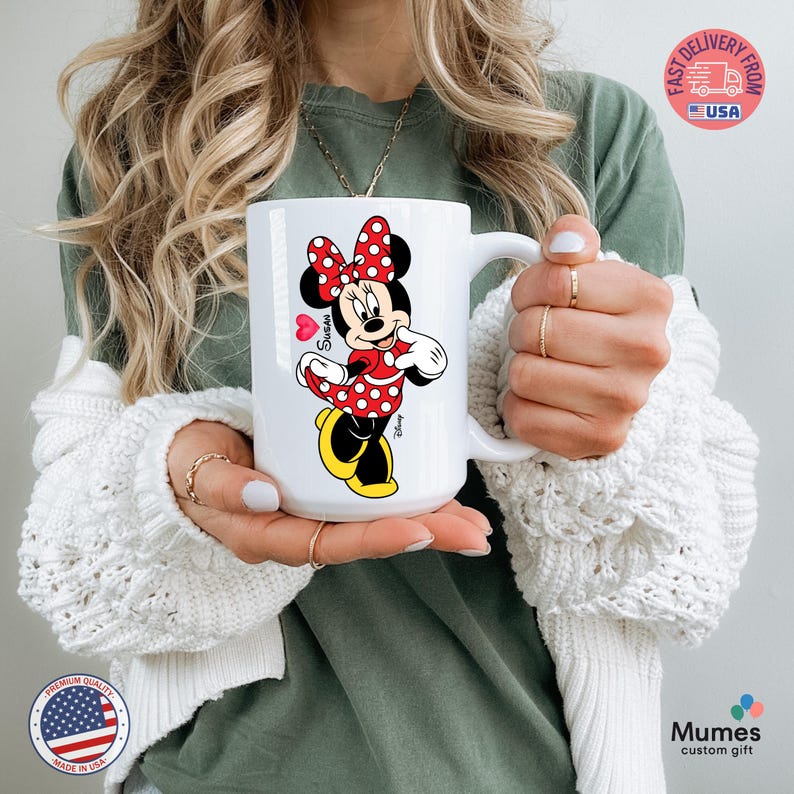 Puede incluir: Taza de cer&aacute;mica blanca con Minnie Mouse con un vestido y lazo de lunares rojos. La taza tiene un asa grande y un coraz&oacute;n con el nombre "Susan". Es un regalo personalizado.