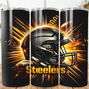 May include: Black stainless steel tumbler with a Steelers football helmet and football design. The design features a black helmet with gold accents and the word "Steelers" in gold. The background has a burst of gold and orange light.