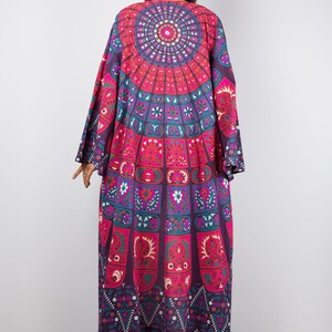 Pu&ograve; includere: Un kimono lungo e fluido di colore viola e rosa con un motivo mandala colorato. Il kimono ha maniche larghe e una vestibilit&agrave; rilassata.