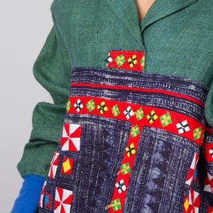 K&ouml;nnte beinhalten: Ein lang&auml;rmeliges Hemd in Gr&uuml;n und Blau mit einem bunten geometrischen Muster. Das Hemd hat einen Kragen und einen Knopfverschluss.