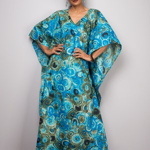 May include: A long, flowing blue and green kaftan with a circular pattern. The kaftan has a V-neck and wide sleeves.