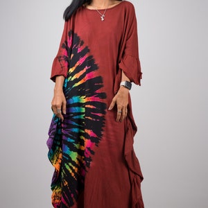 May include: A long, rust-colored, tie-dye dress with a rainbow and black swirl design. The dress has a ruffled hem and three-quarter sleeves.
