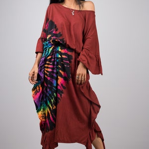 May include: A maroon maxi dress with a colorful tie-dye pattern on the side. The dress has a loose fit and a ruffled hem.