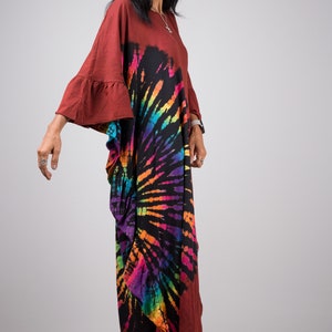 May include: A long, flowing, maroon maxi dress with a tie-dye pattern in shades of rainbow colors. The dress has a loose, comfortable fit and features a round neckline and bell sleeves.