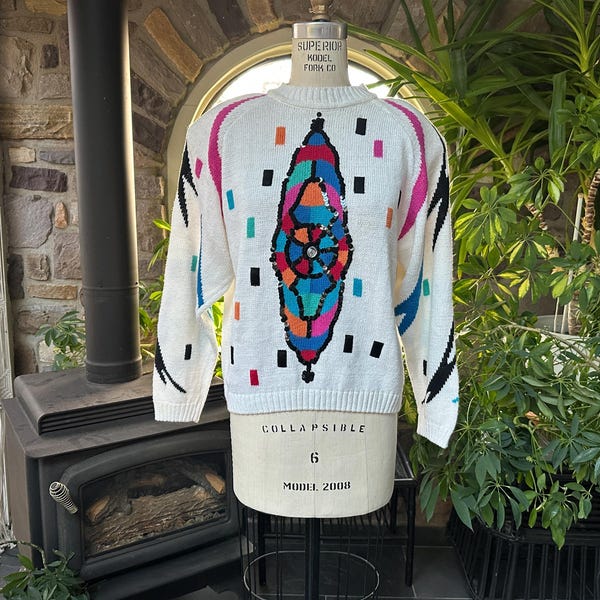 Suéter vintage de los años 80 con diseño de mal de ojo, blanco, azul y rosa, de Oleg Cassini, etiqueta NOS