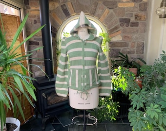 May include: A green and white striped hooded sweater with a zip fastening. The sweater has a relaxed fit and is made from a soft, knitted fabric.