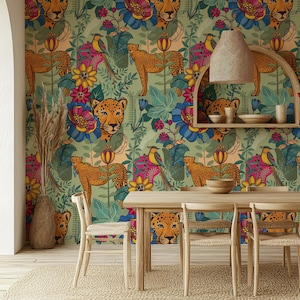 Könnte beinhalten: Ein Esszimmer mit Dschungel-Tapete mit Geparden, Vögeln und bunten Blumen. Der Raum umfasst einen Holztisch, Stühle, einen gewebten Teppich und ein dekoratives Regal. Die Farbpalette wird von Grün, Blau und Pink dominiert.